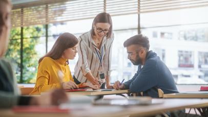 Drei Personen diskutieren Unterlagen auf einem Tisch